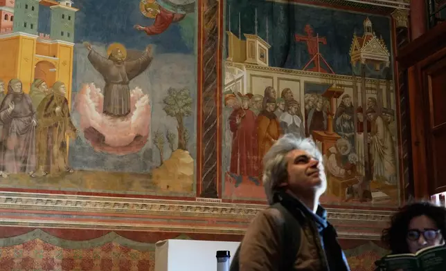 People visit the Basilica of St. Francis with Giotto's frescoes in Assisi, Italy, Saturday, Feb. 21, 2026, on the eve of the public display of St. Francis' remains to mark the 800th anniversary of his death in 1226.(AP Photo/Gregorio Borgia)
