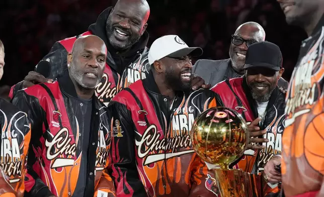 The Miami Heat 2006 NBA championship team pose with the trophy during a half time celebration Tuesday, Feb. 3, 2026, in Miami. (AP Photo/Marta Lavandier)