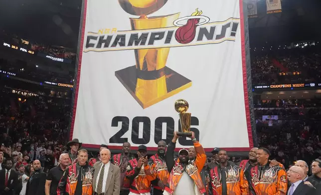 The Miami Heat 2006 NBA championship team pose with the trophy during a half time celebration Tuesday, Feb. 3, 2026, in Miami. (AP Photo/Marta Lavandier)