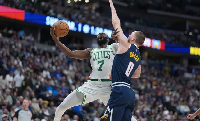 Boston Celtics guard Jaylen Brown, left, drives to the basket as Denver Nuggets guard Christian Braun defends in the first half of an NBA basketball game Wednesday, Feb. 25, 2026, in Denver. (AP Photo/David Zalubowski)