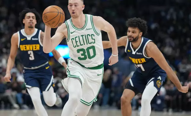 Boston Celtics forward Sam Hauser, front, drives past Denver Nuggets guards Julian Strawther, back left, and Jamal Murray in the first half of an NBA basketball game Wednesday, Feb. 25, 2026, in Denver. (AP Photo/David Zalubowski)
