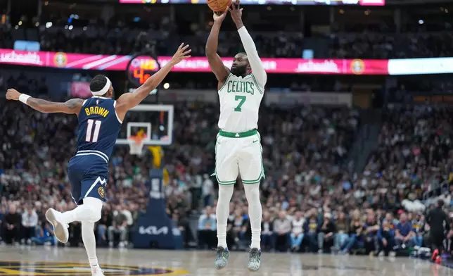 Boston Celtics guard Jaylen Brown, right, shoots for a basket over Denver Nuggets guard Bruce Brown in the first half of an NBA basketball game Wednesday, Feb. 25, 2026, in Denver. (AP Photo/David Zalubowski)