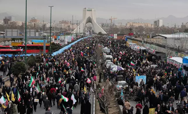 People attend an annual rally marking 1979 Islamic Revolution as the Azadi (Freedom) monument tower is seen at rear in Tehran, Iran, Wednesday, Feb. 11, 2026. (AP Photo/Vahid Salemi)