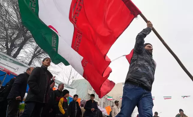 A man waves an Iranian flag during an annual rally marking 1979 Islamic Revolution at the Azadi (Freedom) St. Tehran, Iran, Wednesday, Feb. 11, 2026. (AP Photo/Vahid Salemi)