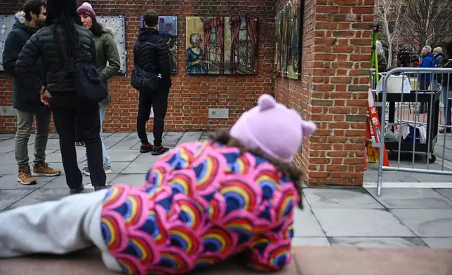 People gather as panels that were part of an exhibit on slavery at the President's House Site in Philadelphia are put back Thursday, Feb. 19, 2026. (AP Photo/Joe Lamberti)