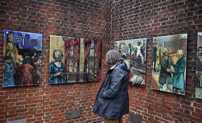 A person views panels that were part of an exhibit on slavery at the President's House Site in Philadelphia after they are put back Thursday, Feb. 19, 2026. (AP Photo/Joe Lamberti)