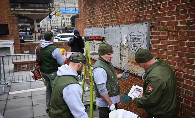 National Parks Service workers talk as panels that were part of an exhibit on slavery at the President's House Site in Philadelphia are put back Thursday, Feb. 19, 2026. (AP Photo/Joe Lamberti)