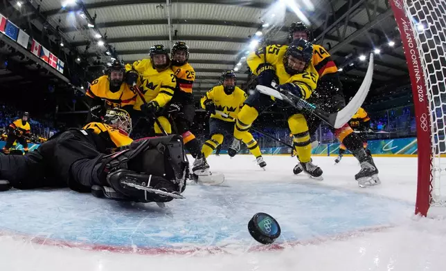 Sweden's Lina Ljungblom, center right, scores her sides opening goal during a preliminary round match of women's ice hockey between Germany and Sweden at the 2026 Winter Olympics, in Milan, Italy, Thursday, Feb. 5, 2026. (AP Photo/Petr David Josek, Pool)
