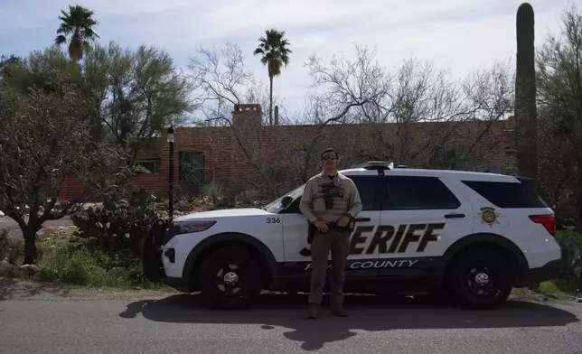 A Pima County Sheriff's Office member stands next to his vehicle in front of Nancy Guthrie's home Tuesday, Feb. 10, 2026 in Tucson, Ariz. (AP Photo/Ty ONeil)