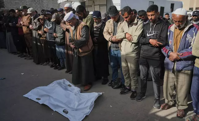 Mourners pray beside the body of Iyad Abu Rabi, 3, who was killed when an Israeli strike hit tents sheltering displaced people along the coast of Khan Younis, according to hospital officials, at Nasser Hospital in Khan Younis, Gaza Strip, Monday, Feb. 2, 2026. (AP Photo/Jehad Alshrafi)