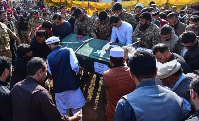 Relatives and army soldiers carry the casket of an army officer, who was killed in the suicide bombing in the border district of Bannu, for his burial following a funeral prayer in Mansehra, Pakistan, Sunday, Feb. 22, 2026. (AP Photo/Saqib Manzoor)