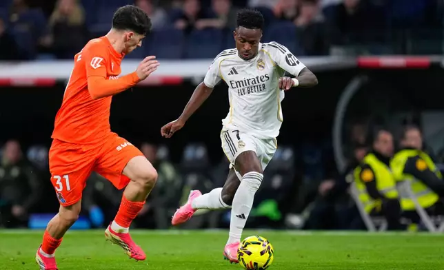 Real Madrid's Vinicius Junior, right, dribbles the ball past Real Sociedad's Jon Martin during the Spanish La Liga soccer match between Real Madrid and Real Sociedad in Madrid, Spain, Saturday, Feb. 14, 2026. (AP Photo/Manu Fernandez)