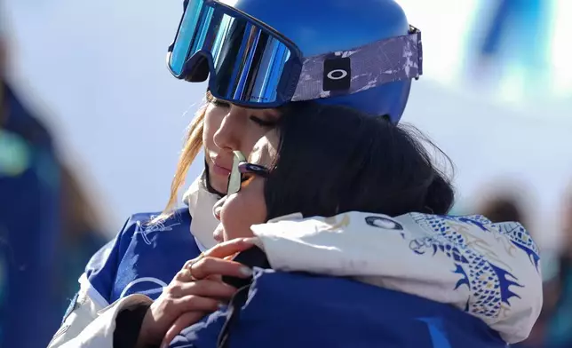 China's Eileen Gu hugs her mother, Yan Gu, during the women's freestyle skiing halfpipe final at the 2026 Winter Olympics, in Livigno, Italy, Sunday, Feb. 22, 2026. (AP Photo/Abbie Parr)