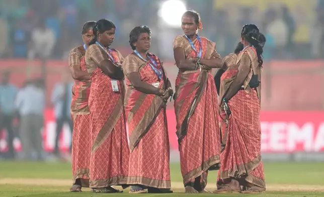 Ground women staff standing near the pitch watch as New Zealand and India players leave after New Zealand won fourth T20 cricket match in Visakhapatnam, India, Wednesday, Jan. 28, 2026. (AP Photo/Aijaz Rahi)