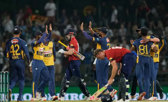 Sri Lanka's players celebrate as England's captain Harry Brook, center, leaves the ground after losing his wicket during the third T20 cricket match between England and Sri Lanka in Pallekele, Sri Lanka, Tuesday, Feb, 3. 2026. (AP Photo/Eranga Jayawardena)