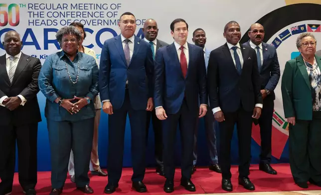 U.S. Secretary of State Marco Rubio, center front in red tie, poses for a group photo with other government officials attending the Caribbean Community (CARICOM) meeting in Basseterre, Saint Kitts and Nevis, Wednesday, Feb. 25, 2026. Also pictured are, Bahamas' Prime Minister Philip Edward Davis, left, Grenada's Prime Minister Dickon Mitchell, fourth from right, Antigua and Barbuda's Prime Minister Gaston Browne, second from right, Barbados' Prime Minister Mia Amor Mottley, second from left, Jamaica's Prime Minister Andrew Holness, front row third from left, and St. Kitts and Nevis Prime Minister Terrance Drew, third from right. (Jonathan Ernst/Pool photo via AP)