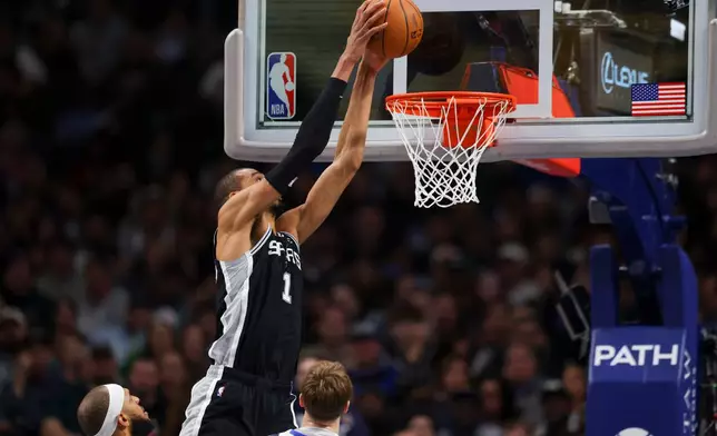 San Antonio Spurs forward Victor Wembanyama (1) dunks in the first half of an NBA basketball game against the Dallas Mavericks Thursday, Feb. 5, 2026, in Dallas. (AP Photo/Gareth Patterson)