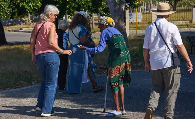 An elderly woman begs for alms from tourists in Havana, Cuba, Thursday, Feb. 26, 2026. (AP Photo/Ramon Espinosa)