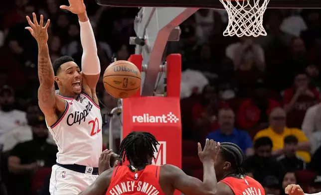 Los Angeles Clippers forward Jordan Miller (22) reacts as he loses control of the ball against Houston Rockets' Dorian Finney-Smith (2) and Clint Capela during the first half of an NBA basketball game, Tuesday, Feb. 10, 2026, in Houston. (AP Photo/ Karen Warren)