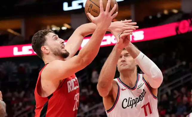 Houston Rockets center Alperen Sengun (28) and Los Angeles Clippers center Brook Lopez (11) reach for the rebound during the first half of an NBA basketball game, Tuesday, Feb. 10, 2026, in Houston. (AP Photo/ Karen Warren)