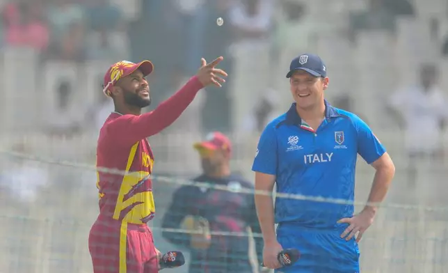 West Indies' captain Shai Hope, left, flips the coin for toss as Italy's captain Wayne Madsen looks on before the start of the T20 World Cup cricket match between West Indies and Italy in Kolkata, India, Thursday, Feb. 19, 2026. (AP Photo/Bikas Das)