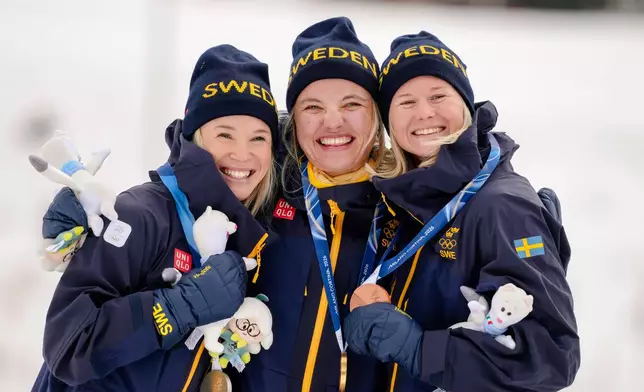 Gold medalist Linn Svahn, center, silver medalist Jonna Sundling, left, and bronze medalist Maja Dahlqvist, all three of Sweden, pose together after the cross-country skiing women's sprint classic at the 2026 Winter Olympics, in Tesero, Italy, Tuesday, Feb. 10, 2026. (AP Photo/Evgeniy Maloletka)