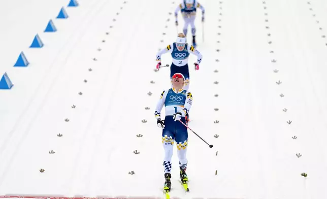 Linn Svahn, of Sweden, crosses the finish line ahead of Jonna Sundling, and Maja Dahlqvist, both also of Sweden, to win the gold medal in cross-country skiing women's sprint classic at the 2026 Winter Olympics, in Tesero, Italy, Tuesday, Feb. 10, 2026. (AP Photo/Matthias Schrader)