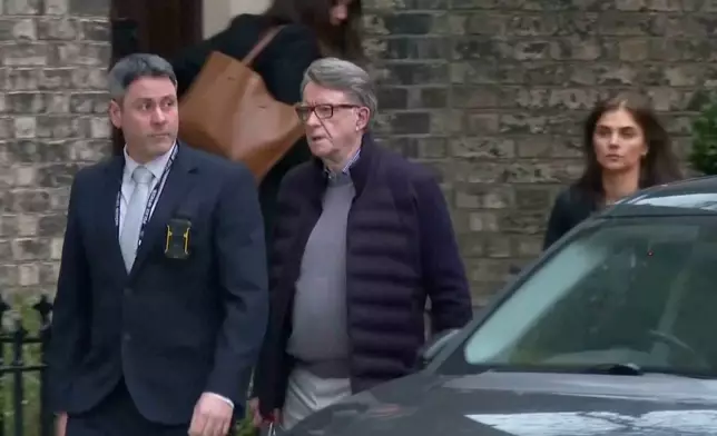 This image taken from video made available by Sky News shows Peter Mandelson, center, escorted from a house to a car, in London, Monday Feb. 23, 2026. (Sky News via AP)