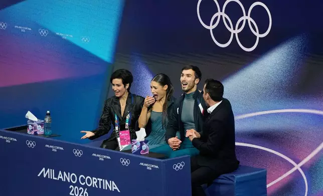 Laurence Fournier Beaudry and Guillaume Cizeron of France react to their scores after competing during the ice dancing free skate in figure skating at the 2026 Winter Olympics, in Milan, Italy, Wednesday, Feb. 11, 2026. (AP Photo/Natacha Pisarenko)