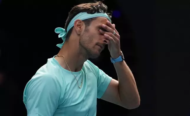 Lorenzo Musetti of Italy reacts as he withdraws from his quarterfinal match against Novak Djokovic of Serbia at the Australian Open tennis championship in Melbourne, Australia, Wednesday, Jan. 28, 2026. (AP Photo/Asanka Brendon Ratnayake)