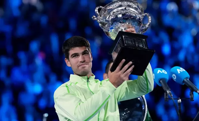Carlos Alcaraz of Spain holds the Norman Brookes Challenge Cup after defeating Novak Djokovic of Serbia in the men's singles final at the Australian Open tennis championship in Melbourne, Australia, Sunday, Feb. 1, 2026. (AP Photo/Aaron Favila)