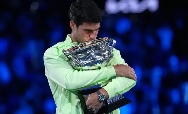 Carlos Alcaraz of Spain holds the Norman Brookes Challenge Cup after defeating Novak Djokovic of Serbia in the men's singles final at the Australian Open tennis championship in Melbourne, Australia, Sunday, Feb. 1, 2026. (AP Photo/Dita Alangkara)