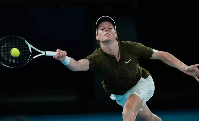 Jannik Sinner of Italy plays a forehand return to Novak Djokovic of Serbia during their semifinal match at the Australian Open tennis championship in Melbourne, Australia, Friday, Jan. 30, 2026. (AP Photo/Aaron Favila)