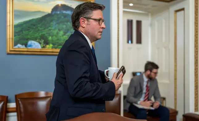 Speaker of the House Mike Johnson, R-La., walks through the House Rules Committee hearing room to meet with Republicans on the panel as they try to advance a federal funding package and prevent a prolonged partial government shutdown, at the Capitol in Washington, Monday, Feb. 2, 2026. (AP Photo/J. Scott Applewhite)