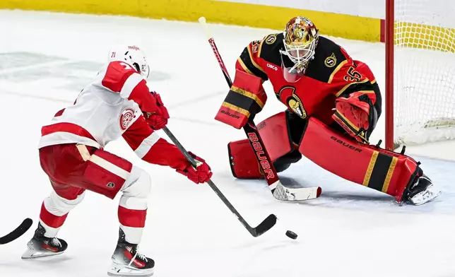 Detroit Red Wings' Dylan Larkin (71) scores on Ottawa Senators' goaltender Linus Ullmark (35) during overtime of an NHL hockey game, in Ottawa, Ontario, Thursday, Feb. 26, 2026. (Spencer Colby/The Canadian Press via AP)
