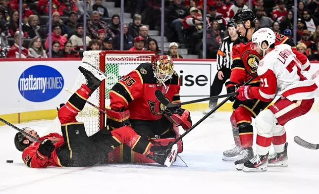 Ottawa Senators' Jake Sanderson (85) crashes to the ice in front of goaltender Linus Ullmark (35) during the first period of an NHL hockey game against the Detroit Red Wings, in Ottawa, Ontario, Thursday, Feb. 26, 2026. (Spencer Colby/The Canadian Press via AP)