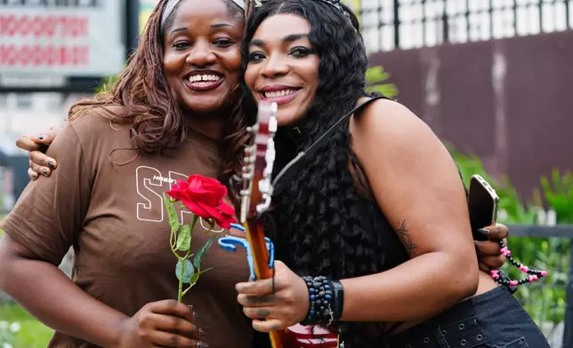 Nigerian rock musician Bianca “Clayrocksu” Okorocha, right, poses for a photograph with Barbara Lulu, a Lagos resident, left, after handing her a single-stem rose ahead of Valentine's Day in Lagos, Nigeria, Tuesday, Feb.10, 2026. (AP Photo/Sunday Alamba)