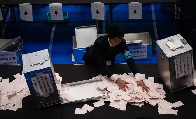 Election officials open ballot boxes as they prepare to count the votes in the lower house election in Tokyo, Sunday, Feb. 8, 2026. (AP Photo/Louise Delmotte)