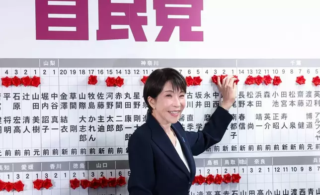 Sanae Takaichi, center, Japan's prime minister and president of the ruling Liberal Democratic Party (LDP), puts pins marking the names of candidates who won lower house elections, at the LDP headquarters Sunday, Feb. 8, 2026 in Tokyo, (Kim Kyung-Hoon/Pool Photo via AP)