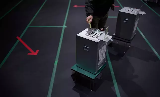 A voter casts a ballot in the upper house election at a polling station Sunday, Feb. 8, 2026, in Tokyo. (AP Photo/Louise Delmotte)