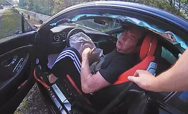 In an image taken from Connecticut State Police police bodycam video, Vince McMahon is questioned in his car after an accident on July 24, 2025, in Westport, Conn. (Connecticut State Police via AP)
