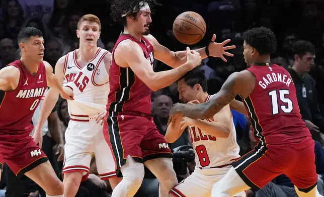 Miami Heat forward Jaime Jaquez Jr., third from left, and forward Myron Gardner (15) defend Chicago Bulls guard Yuki Kawamura (8) during the first half of an NBA basketball game, Saturday, Jan. 31, 2026, in Miami. (AP Photo/Lynne Sladky)
