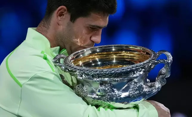 Carlos Alcaraz of Spain holds the Norman Brookes Challenge Cup after defeating Novak Djokovic of Serbia in the men's singles final at the Australian Open tennis championship in Melbourne, Australia, Sunday, Feb. 1, 2026. (AP Photo/Aaron Favila)