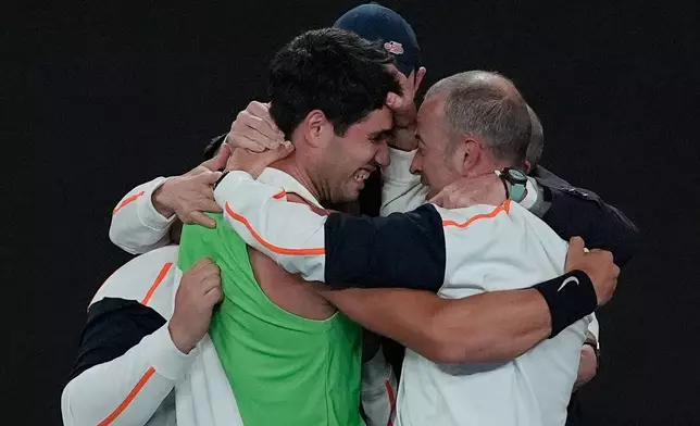 Carlos Alcaraz of Spain, left, celebrates with his team after defeating Novak Djokovic of Serbia in the men's singles final at the Australian Open tennis championship in Melbourne, Australia, Sunday, Feb. 1, 2026. (AP Photo/Asanka Brendon Ratnayake)