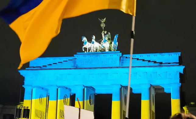 FILE - People attend a demonstration in front of the Brandenburg Gate in Berlin, Germany, to mark the fourth anniversary of the Russian invasion of Ukraine, Feb. 24, 2026. (AP Photo/Markus Schreiber, File)
