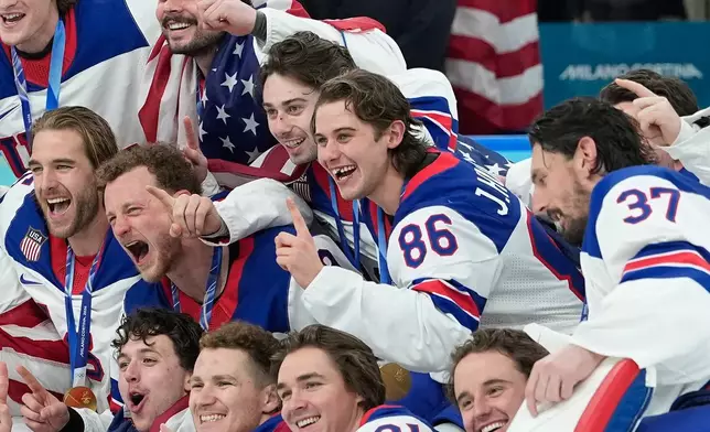 United States' Jack Hughes (86) poses with teammates after a men's ice hockey gold medal game between Canada and the United States at the 2026 Winter Olympics, in Milan, Italy, Sunday, Feb. 22, 2026. (AP Photo/Petr David Josek)