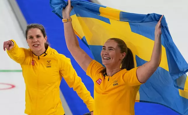 Sweden's Anna Hasselborg, left, and Sara McManus celebrate winning a women's curling gold medal match between Switzerland and Sweden, at the 2026 Winter Olympics, in Cortina d'Ampezzo, Italy, Sunday, Feb. 22, 2026. (AP Photo/Fatima Shbair)