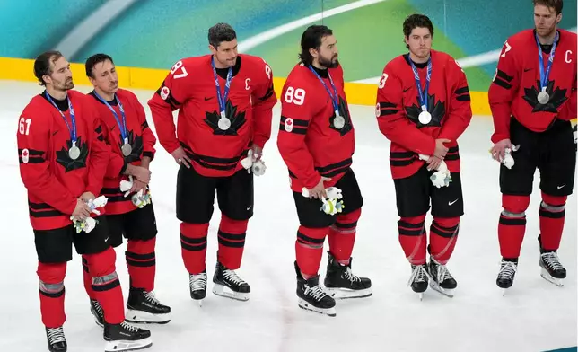 Canada's Sidney Crosby (87) stands with his teammates during the medal ceremony following Canada's overtime loss to the United States in the men's ice hockey gold medal game at the 2026 Winter Olympics in Milan, Italy, Sunday, Feb. 22, 2026. (AP Photo/Carolyn Kaster)