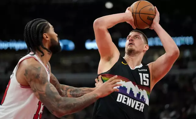 Denver Nuggets center Nikola Jokic (15), right, handles the ball as Chicago Bulls center Nick Richards (13) defends during the second half of an NBA basketball game Saturday, Feb. 7, 2026, in Chicago. (AP Photo/Erin Hooley)