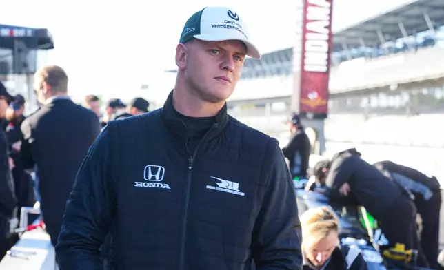FILE - Race driver Mick Schumacher watches from the pit area as he participates in auto racing testing on the road coarse at Indianapolis Motor Speedway, Monday, Oct. 13, 2025, in Indianapolis. (AP Photo/Michael Conroy, File(